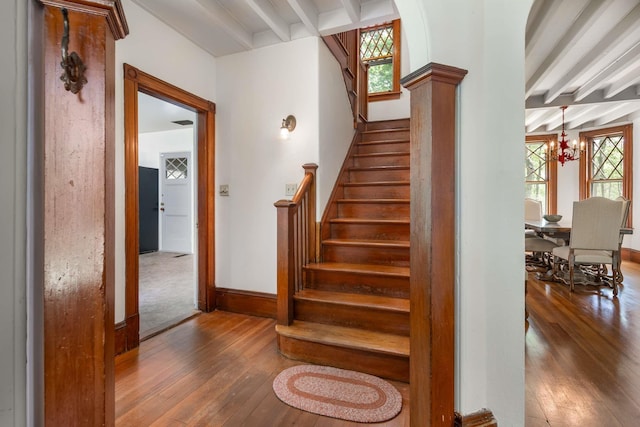 4 Fairbourne Ln, York, ME 03902 - stairs featuring beamed ceiling, wood-type flooring, and a chandelier