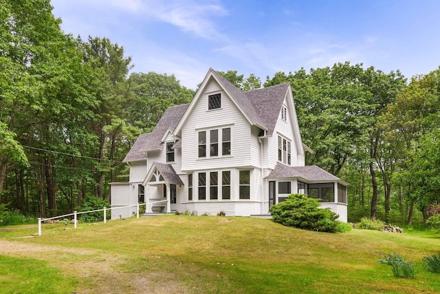 4 Fairbourne Ln, York, ME 03902 - view of front facade featuring a shingled roof, a front yard, a sunroom, and view of scattered trees