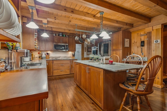 7 Reidy Way, Littleton, NH 03561 - kitchen with appliances with stainless steel finishes, a wooden ceiling with exposed beams, dark wood-style flooring, brown cabinets, and wood walls