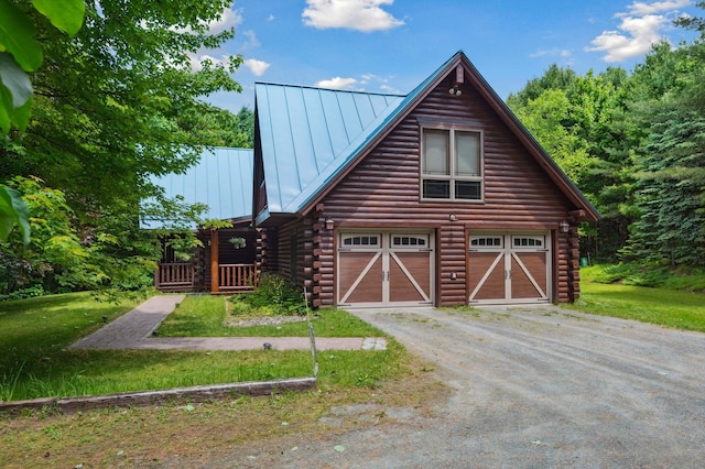7 Reidy Way, Littleton, NH 03561 - view of front of home featuring log siding, a standing seam roof, driveway, a garage, and a metal roof