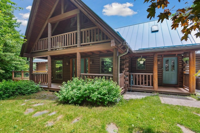7 Reidy Way, Littleton, NH 03561 - view of front facade with log siding, a standing seam roof, a porch, and a metal roof