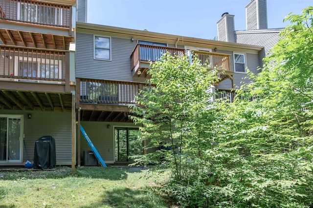 19 Village Falls Way, Merrimack, NH 03054 - rear view of property with a chimney, a deck, and a lawn