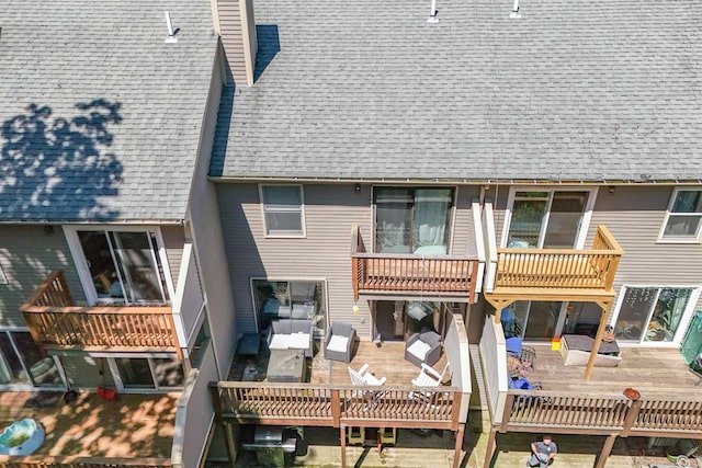 19 Village Falls Way, Merrimack, NH 03054 - back of property featuring a chimney, a shingled roof, and a balcony