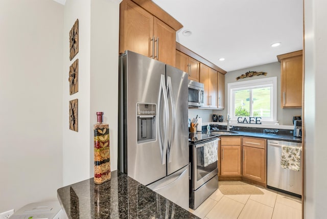 53 Evergreens Dr Unit 3, Laconia, NH 03246 - kitchen with appliances with stainless steel finishes, dark stone counters, light tile patterned floors, recessed lighting, and brown cabinets