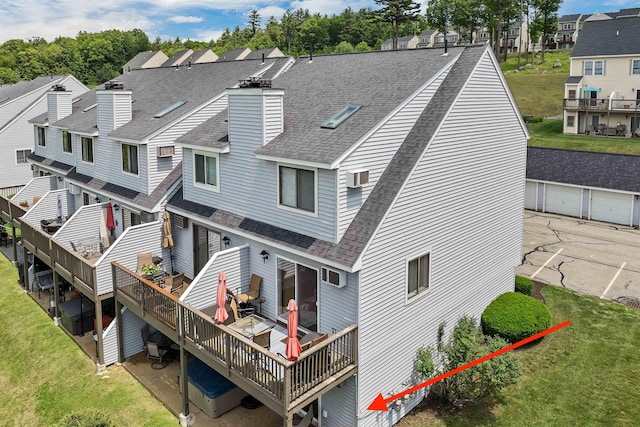 53 Evergreens Dr Unit 3, Laconia, NH 03246 - rear view of property featuring a shingled roof, a deck, a chimney, a residential view, and a lawn