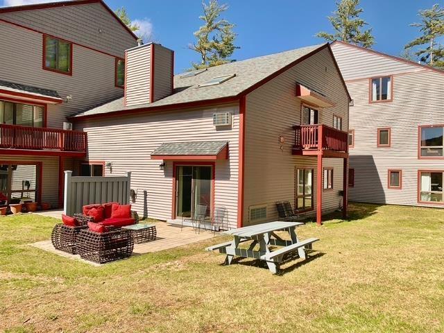 3 River Run Dr Unit A, Bartlett, NH 03812 - back of property with a chimney, a balcony, a yard, a patio, and outdoor lounge area