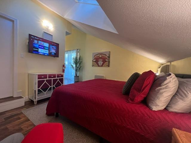 3 River Run Dr Unit A, Bartlett, NH 03812 - bedroom with lofted ceiling, wood finished floors, and a textured ceiling