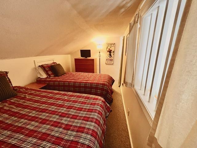 3 River Run Dr Unit A, Bartlett, NH 03812 - bedroom with vaulted ceiling, carpet flooring, and a textured ceiling
