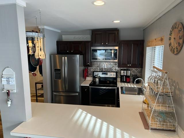 3 River Run Dr Unit A, Bartlett, NH 03812 - kitchen with stainless steel appliances, light countertops, backsplash, ornamental molding, and dark brown cabinetry