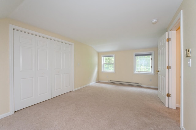 126 Flintlock Vlg Unit 3, Wells, ME 04090 - unfurnished bedroom with baseboard heating, carpet, vaulted ceiling, and a closet