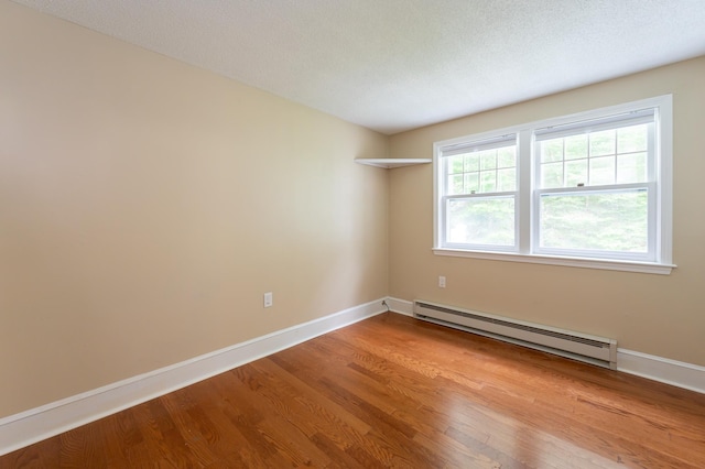 126 Flintlock Vlg Unit 3, Wells, ME 04090 - empty room featuring a baseboard radiator and wood finished floors