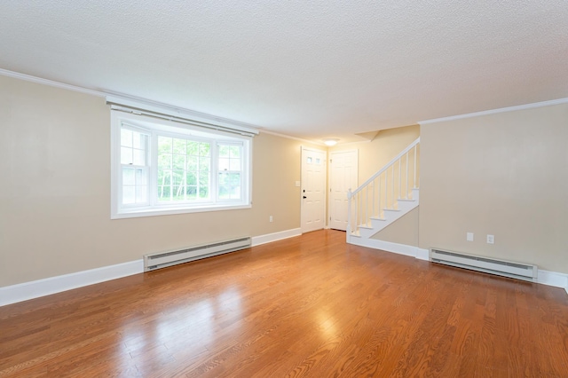 126 Flintlock Vlg Unit 3, Wells, ME 04090 - unfurnished living room featuring a baseboard radiator, stairs, crown molding, wood finished floors, and a textured ceiling
