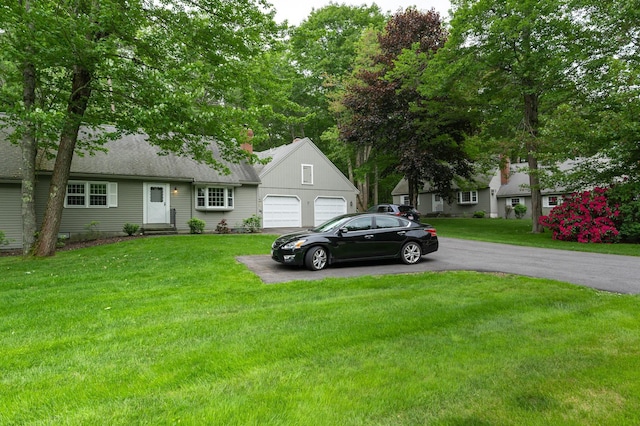 126 Flintlock Vlg Unit 3, Wells, ME 04090 - view of front of house featuring driveway, an attached garage, and a front lawn