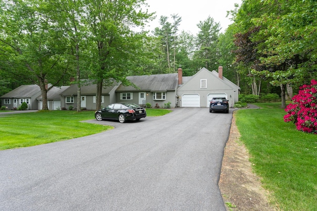 126 Flintlock Vlg Unit 3, Wells, ME 04090 - view of front of home with an attached garage, a chimney, asphalt driveway, and a front yard