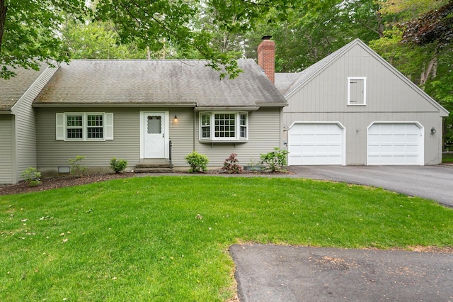 126 Flintlock Vlg Unit 3, Wells, ME 04090 - view of front of house with a chimney, asphalt driveway, an attached garage, a front lawn, and a shingled roof