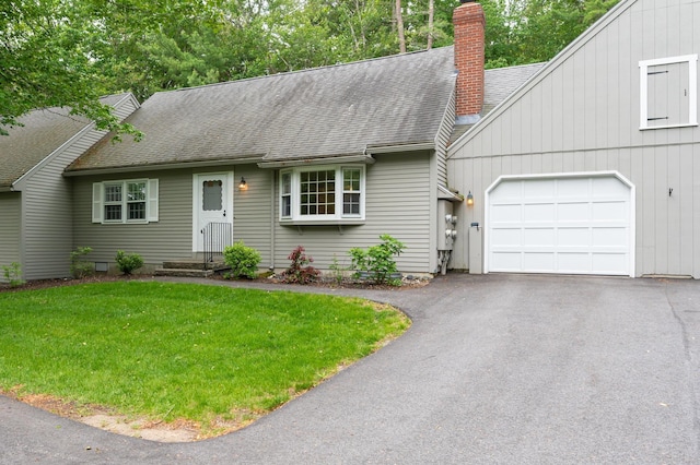 126 Flintlock Vlg Unit 3, Wells, ME 04090 - view of front of home featuring a garage, a chimney, roof with shingles, asphalt driveway, and a front yard