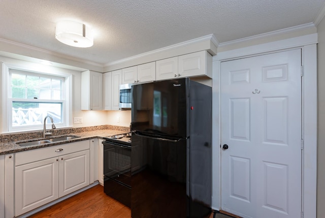 126 Flintlock Vlg Unit 3, Wells, ME 04090 - kitchen with black appliances, ornamental molding, light wood-style floors, white cabinets, and dark stone countertops