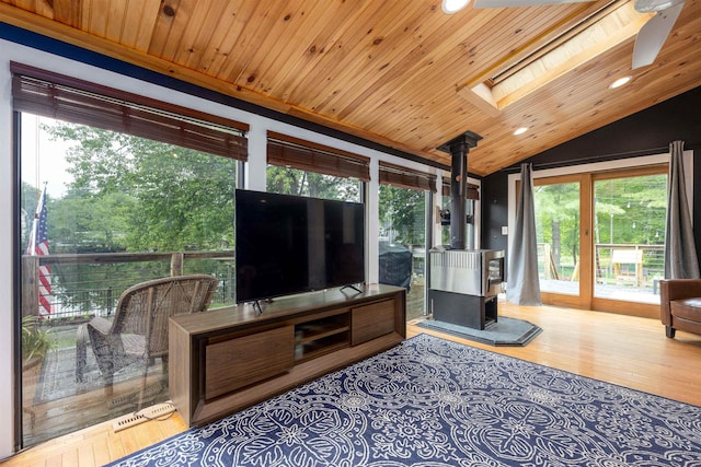 12 Water Rd, Goffstown, NH 03045 - sunroom / solarium featuring a wood stove, a skylight, lofted ceiling, and plenty of natural light