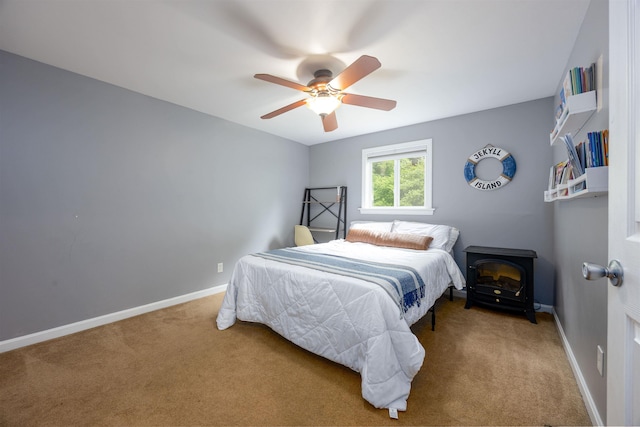 12 Water Rd, Goffstown, NH 03045 - bedroom with carpet flooring, a wood stove, and a ceiling fan