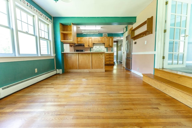 123 S Lincoln St, Keene, NH 03431 - kitchen featuring freestanding refrigerator, a peninsula, light wood finished floors, a baseboard radiator, and light countertops