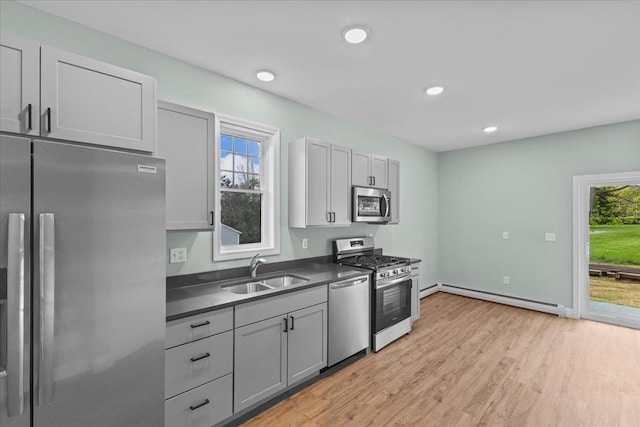 23 Ferris St Unit 102, Saint Albans City, VT 05478 - kitchen with stainless steel appliances, baseboard heating, dark countertops, light wood-style flooring, and recessed lighting