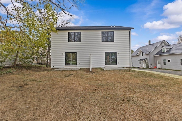 23 Ferris St Unit 102, Saint Albans City, VT 05478 - rear view of house featuring a lawn and a patio area