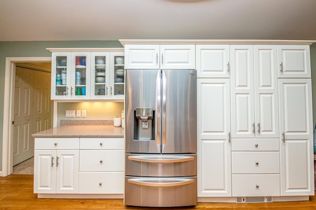 231 Grandview Rd, Conway, NH 03818 - kitchen featuring stainless steel refrigerator with ice dispenser, glass insert cabinets, white cabinets, light stone countertops, and light wood finished floors
