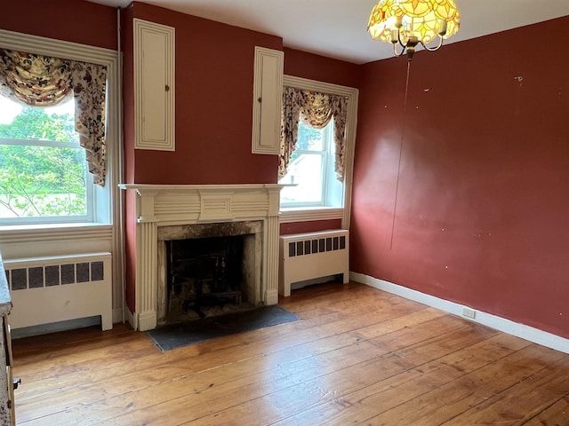 249 Ward Rd, Poultney, VT 05764 - unfurnished living room with radiator heating unit, light wood-type flooring, and a premium fireplace