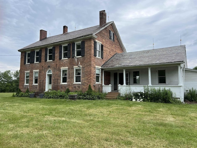249 Ward Rd, Poultney, VT 05764 - colonial home featuring a porch, a front lawn, a chimney, and brick siding