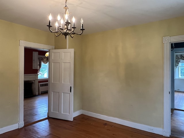 249 Ward Rd, Poultney, VT 05764 - unfurnished dining area with radiator, dark wood-style floors, a chandelier, and healthy amount of natural light