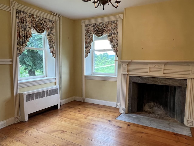 249 Ward Rd, Poultney, VT 05764 - detailed view of radiator, wood finished floors, a chandelier, and a fireplace