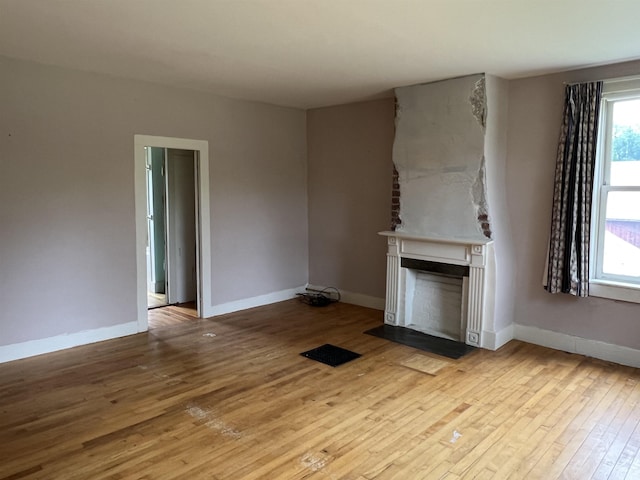 249 Ward Rd, Poultney, VT 05764 - unfurnished living room featuring wood-type flooring and a fireplace with flush hearth