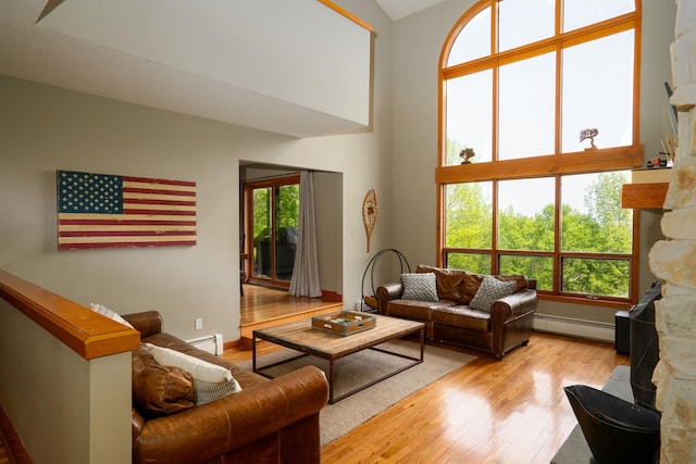 25 Benson Fuller Rd, Winhall, VT 05340 - living area with a baseboard radiator, light wood-style floors, plenty of natural light, and a towering ceiling