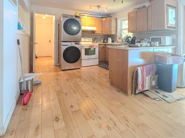 1 Wyeth Farm Cir, Lebanon, NH 03784 - kitchen featuring white appliances, estacked washer and dryer, under cabinet range hood, light wood finished floors, and backsplash