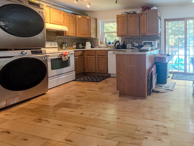 1 Wyeth Farm Cir, Lebanon, NH 03784 - kitchen featuring white appliances, estacked washer and dryer, under cabinet range hood, and backsplash