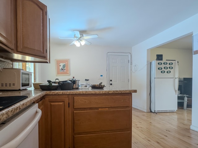 1 Wyeth Farm Cir, Lebanon, NH 03784 - kitchen with white appliances, ceiling fan, a peninsula, light wood-type flooring, and brown cabinetry