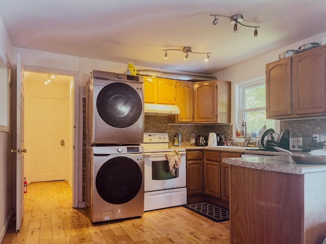 1 Wyeth Farm Cir, Lebanon, NH 03784 - kitchen with electric stove, stacked washing machine and dryer, light wood-type flooring, decorative backsplash, and under cabinet range hood