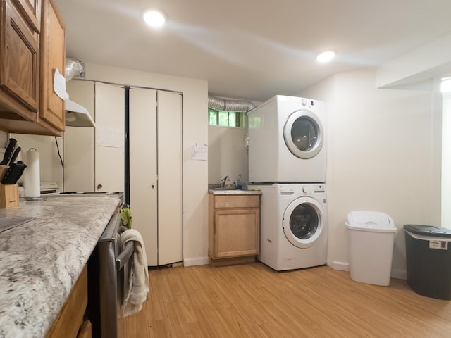 1 Wyeth Farm Cir, Lebanon, NH 03784 - laundry area with stacked washer and clothes dryer, light wood-style flooring, and cabinet space