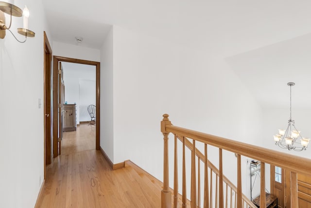 490 W Hill Rd, Ludlow, VT 05149 - hallway with a chandelier, an upstairs landing, and light wood-style floors