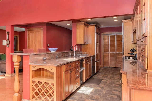 3 Mooreland Ave, Concord, NH 03301 - kitchen with light stone counters, recessed lighting, appliances with stainless steel finishes, brown cabinetry, and a peninsula