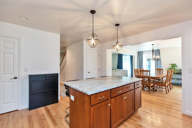 116 Sullivan Center Rd, Gilsum, NH 03448 - kitchen featuring brown cabinets, pendant lighting, light wood-style floors, a chandelier, and light stone countertops