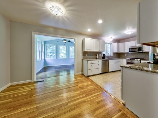 8 Sycamore Ct, Amherst, NH 03031 - kitchen with stainless steel appliances, white cabinetry, backsplash, light wood-type flooring, and a ceiling fan