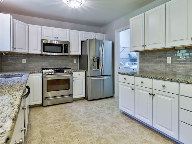 8 Sycamore Ct, Amherst, NH 03031 - kitchen with appliances with stainless steel finishes, separate washer and dryer, tasteful backsplash, and white cabinetry