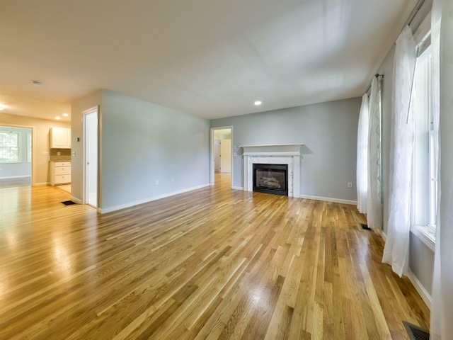 8 Sycamore Ct, Amherst, NH 03031 - unfurnished living room featuring light wood-style flooring, a glass covered fireplace, and recessed lighting