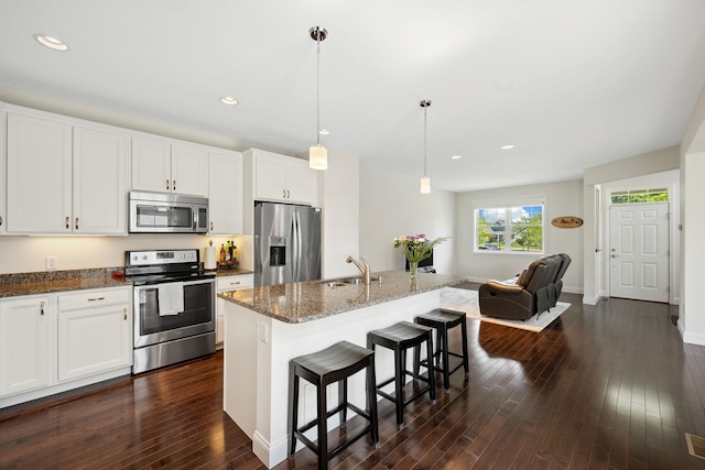 394 Zephyr Rd, Williston, VT 05495 - kitchen featuring appliances with stainless steel finishes, dark wood-type flooring, dark stone counters, a kitchen breakfast bar, and recessed lighting