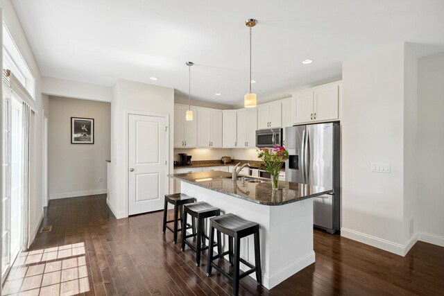 394 Zephyr Rd, Williston, VT 05495 - kitchen featuring stainless steel appliances, a kitchen breakfast bar, dark wood-style floors, dark stone counters, and recessed lighting