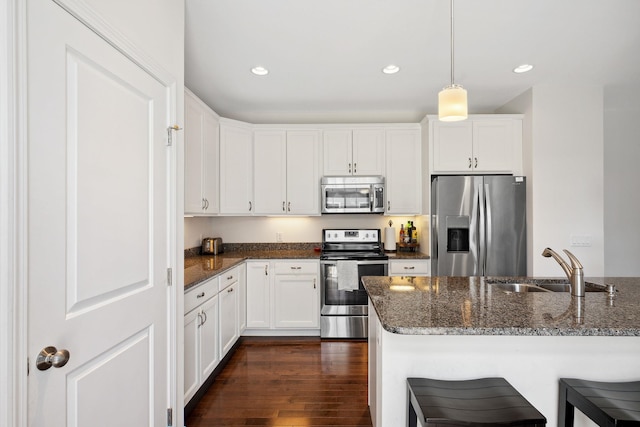 394 Zephyr Rd, Williston, VT 05495 - kitchen featuring appliances with stainless steel finishes, recessed lighting, a breakfast bar, dark stone counters, and dark wood-type flooring