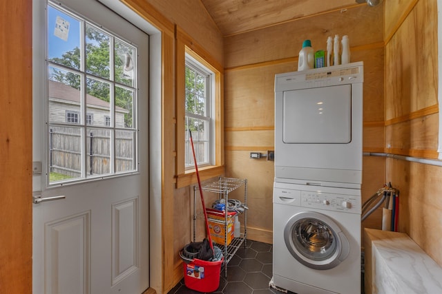 19 Baker St, Dover, NH 03820 - laundry area featuring stacked washer and clothes dryer, wooden walls, and tile patterned flooring