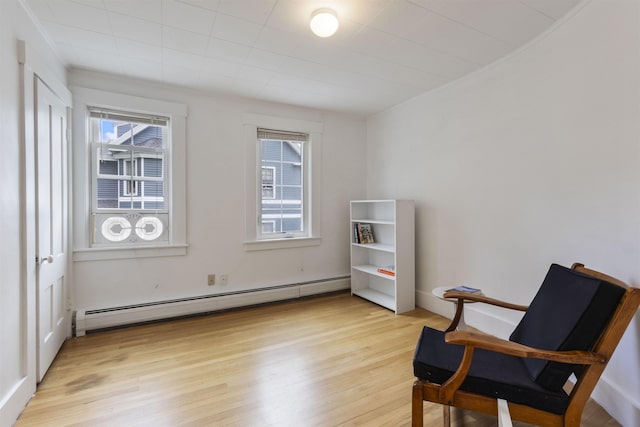 19 Baker St, Dover, NH 03820 - living area with a baseboard heating unit, plenty of natural light, and light wood-type flooring
