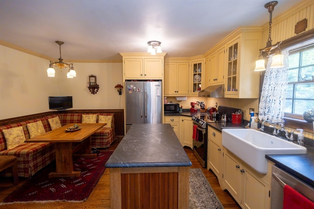 185 Huntress Bridge Rd, Effingham, NH 03882 - kitchen with appliances with stainless steel finishes, under cabinet range hood, dark countertops, cream cabinets, and glass insert cabinets